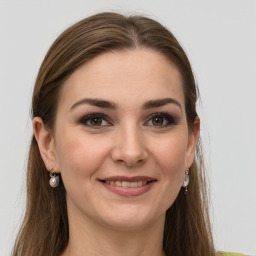 Joyful white young-adult female with long  brown hair and green eyes