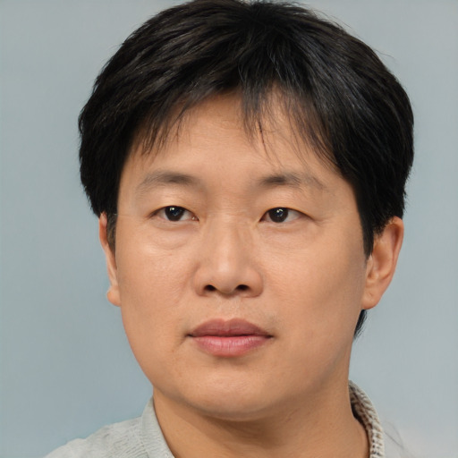 Joyful asian adult male with short  brown hair and brown eyes