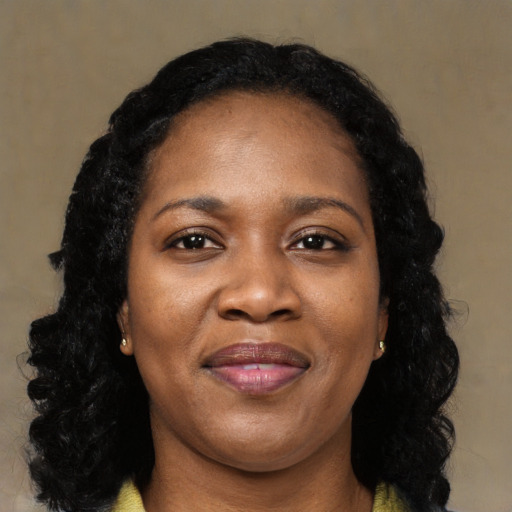 Joyful black young-adult female with long  black hair and brown eyes