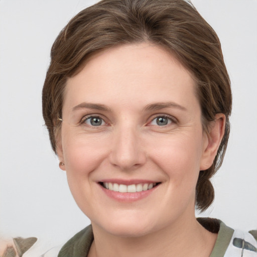 Joyful white young-adult female with medium  brown hair and grey eyes