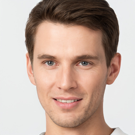 Joyful white young-adult male with short  brown hair and grey eyes