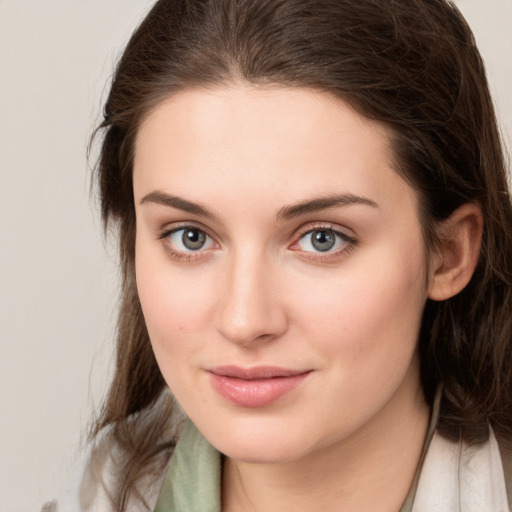 Joyful white young-adult female with medium  brown hair and green eyes