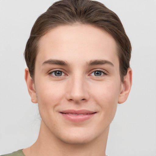 Joyful white young-adult female with short  brown hair and grey eyes