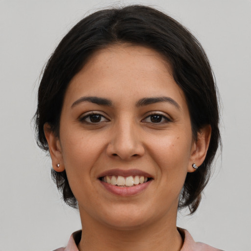 Joyful latino young-adult female with medium  brown hair and brown eyes