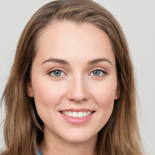 Joyful white young-adult female with long  brown hair and blue eyes