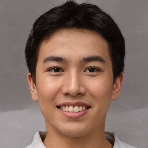 Joyful asian young-adult male with short  brown hair and brown eyes