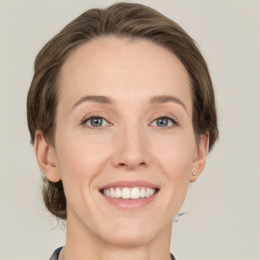 Joyful white young-adult female with medium  brown hair and green eyes