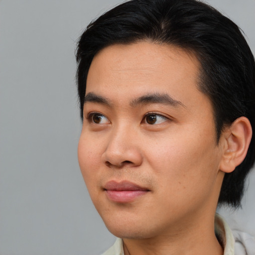 Joyful asian young-adult male with short  brown hair and brown eyes