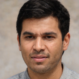 Joyful white adult male with short  black hair and brown eyes