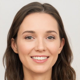 Joyful white young-adult female with long  brown hair and brown eyes