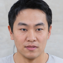 Joyful asian young-adult male with short  black hair and brown eyes