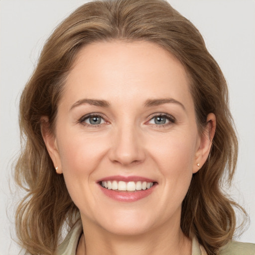 Joyful white young-adult female with medium  brown hair and green eyes