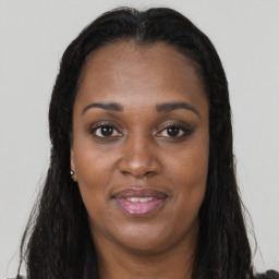Joyful black young-adult female with long  brown hair and brown eyes