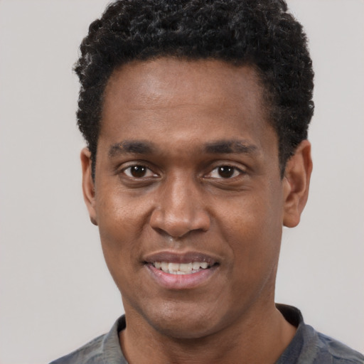 Joyful black young-adult male with short  black hair and brown eyes