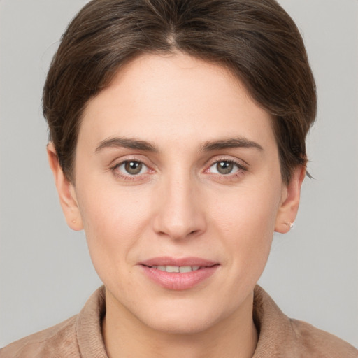 Joyful white young-adult female with short  brown hair and grey eyes