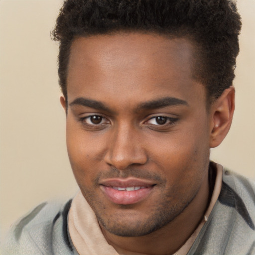 Joyful black young-adult male with short  brown hair and brown eyes