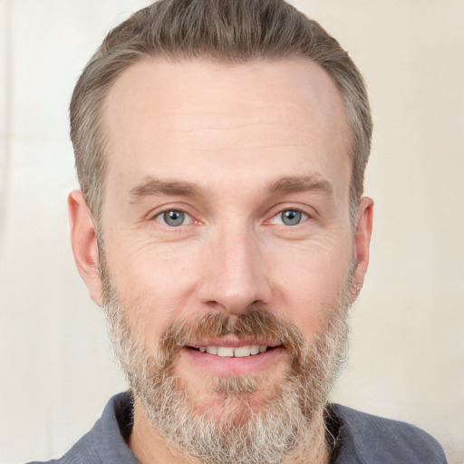 Joyful white adult male with short  brown hair and grey eyes