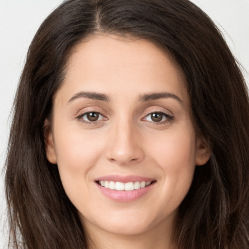 Joyful white young-adult female with long  brown hair and brown eyes