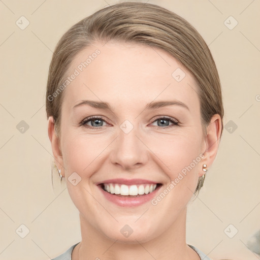 Joyful white young-adult female with medium  brown hair and grey eyes