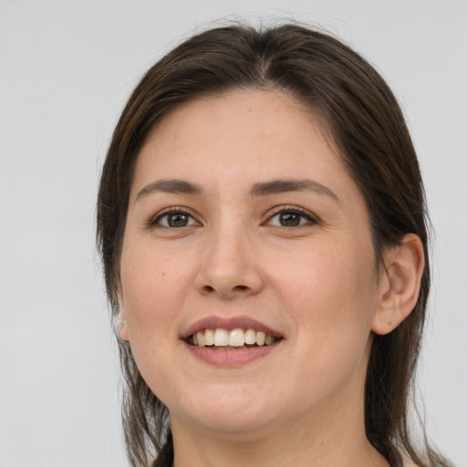 Joyful white young-adult female with medium  brown hair and grey eyes