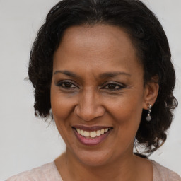 Joyful black adult female with medium  brown hair and brown eyes