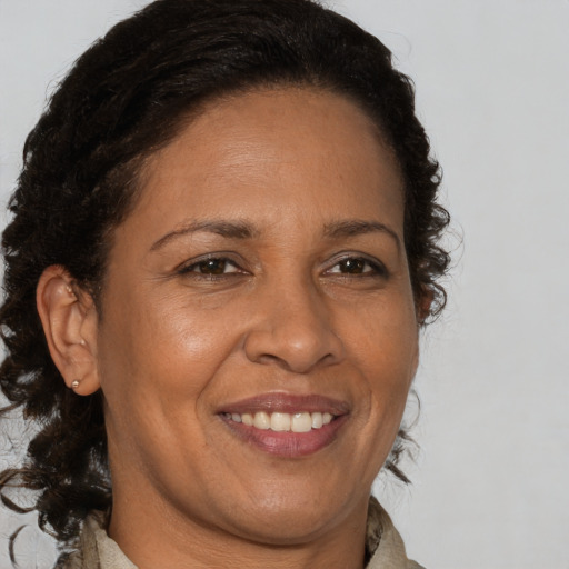 Joyful black adult female with long  brown hair and brown eyes