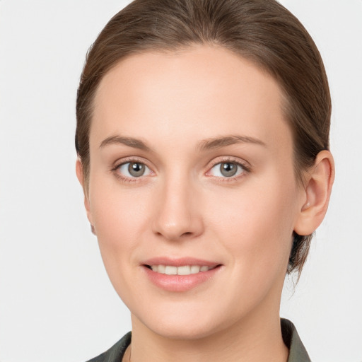 Joyful white young-adult female with medium  brown hair and grey eyes