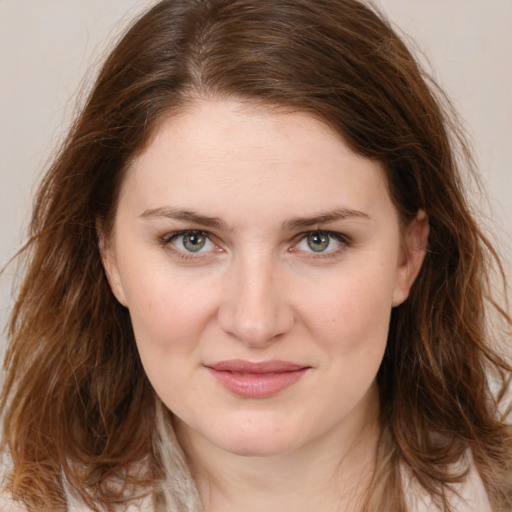 Joyful white young-adult female with long  brown hair and green eyes