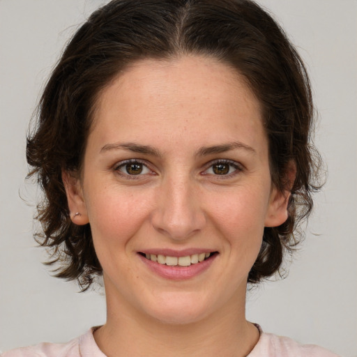 Joyful white young-adult female with medium  brown hair and green eyes