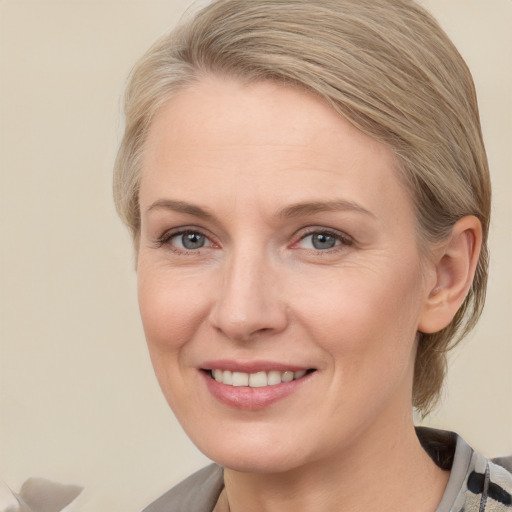 Joyful white adult female with medium  brown hair and blue eyes