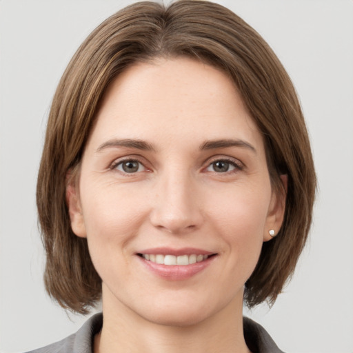 Joyful white young-adult female with medium  brown hair and grey eyes