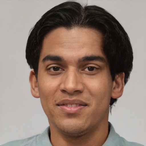 Joyful white young-adult male with short  black hair and brown eyes