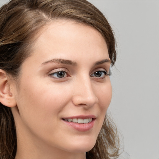 Joyful white young-adult female with long  brown hair and blue eyes