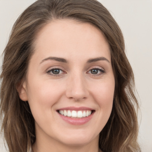 Joyful white young-adult female with long  brown hair and grey eyes