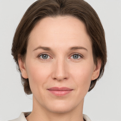 Joyful white young-adult female with medium  brown hair and grey eyes