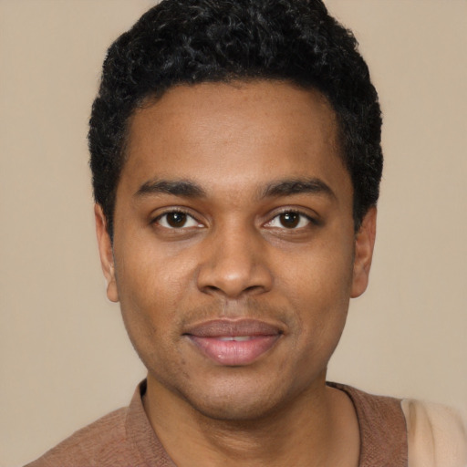 Joyful black young-adult male with short  black hair and brown eyes