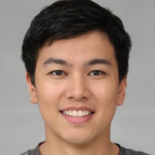 Joyful asian young-adult male with short  brown hair and brown eyes