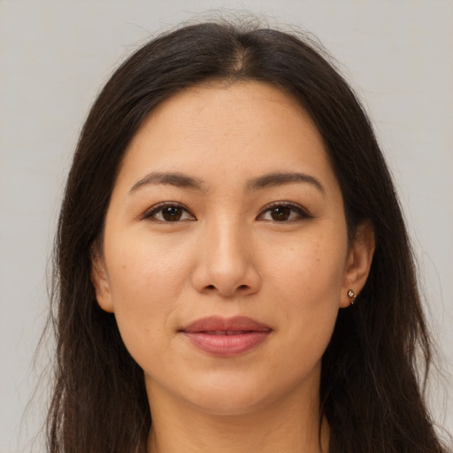 Joyful latino young-adult female with long  brown hair and brown eyes
