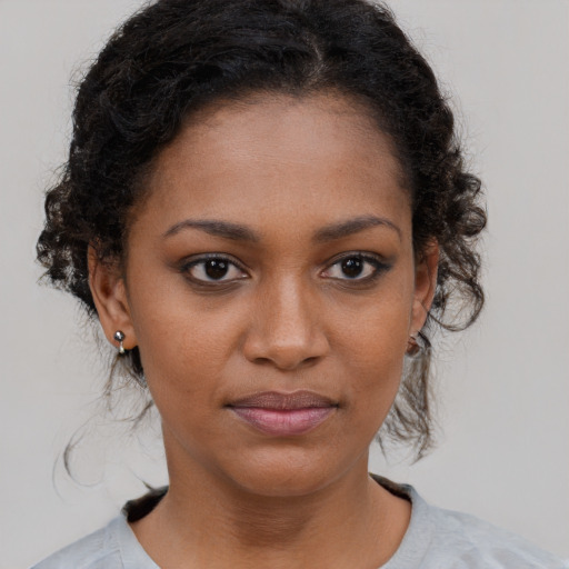 Joyful black young-adult female with medium  brown hair and brown eyes