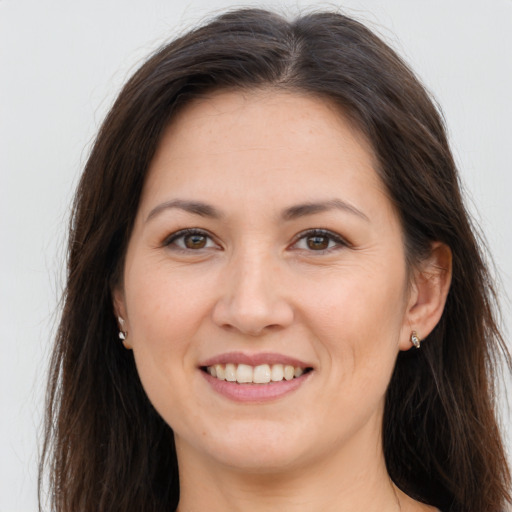 Joyful white young-adult female with long  brown hair and brown eyes