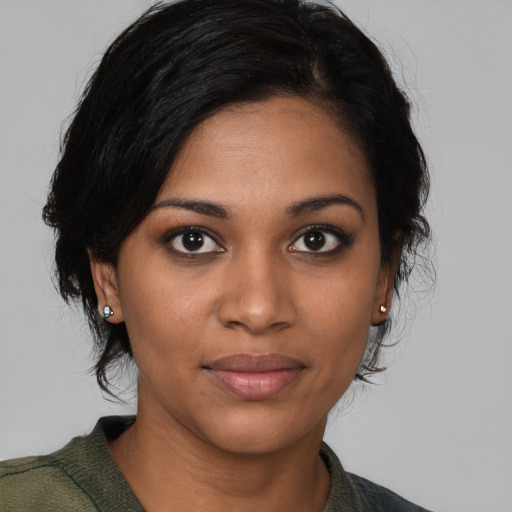 Joyful black young-adult female with medium  brown hair and brown eyes