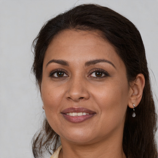 Joyful latino adult female with long  brown hair and brown eyes