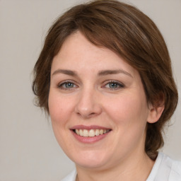 Joyful white young-adult female with medium  brown hair and grey eyes