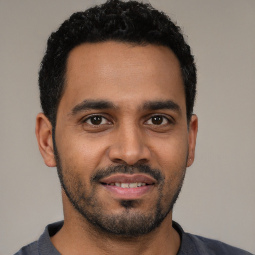 Joyful latino young-adult male with short  black hair and brown eyes