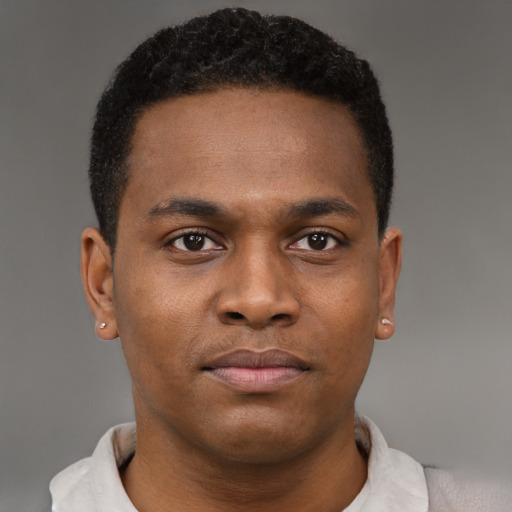Joyful black young-adult male with short  brown hair and brown eyes