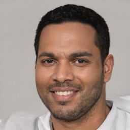 Joyful white young-adult male with short  black hair and brown eyes