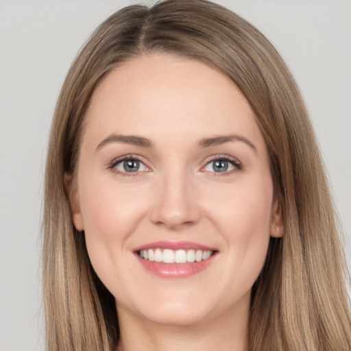 Joyful white young-adult female with long  brown hair and grey eyes