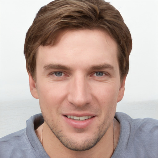 Joyful white young-adult male with short  brown hair and grey eyes