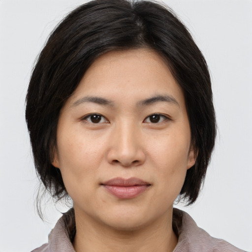 Joyful asian young-adult female with medium  brown hair and brown eyes
