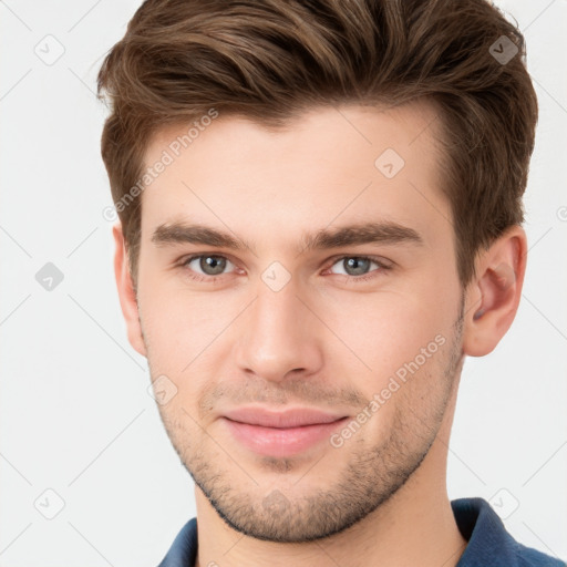 Joyful white young-adult male with short  brown hair and grey eyes